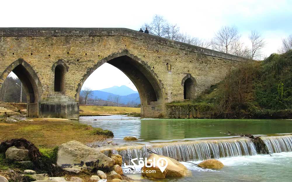 پلی قدیمی و آجری روی یک رودخاه به نام پل شاپور 