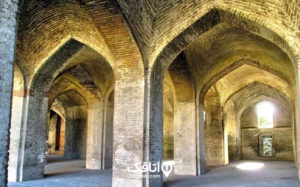 داخل ساختمانی با ستون های پهن و سقف طاقی شکل و آجری به نام مسجد شاه عباسی