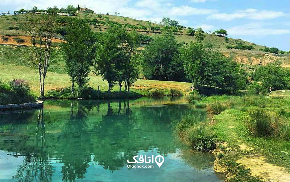 تفرجگاه شیرچشمه یک زمین سرسبز با یک رودخانه که وسط آن رد میشود