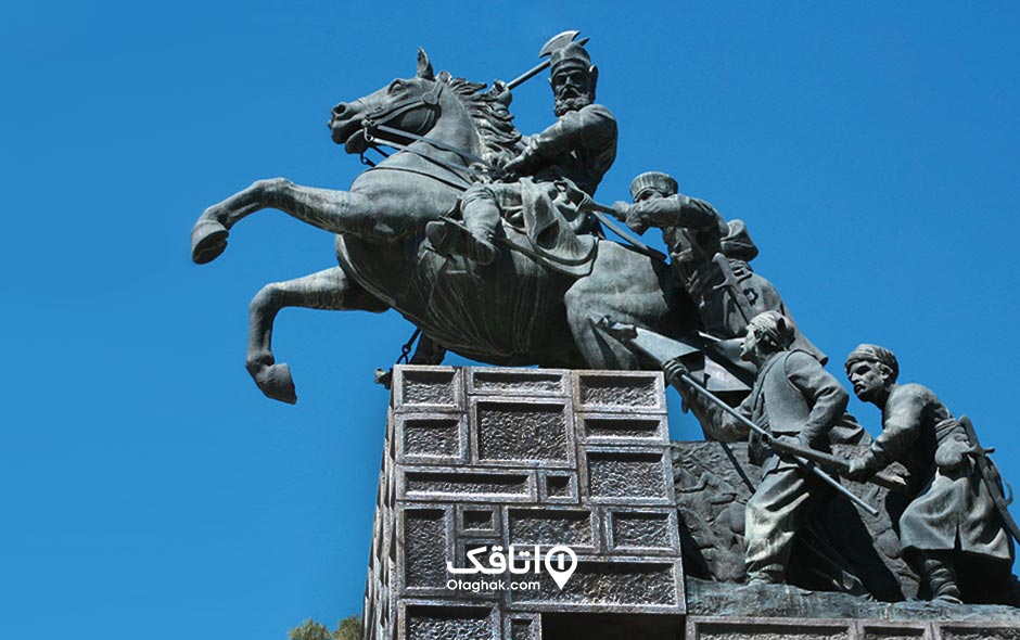 مجسمه ینادر شاه سوار بر اسب و چند مرد در حال تلاش برای انداختن او