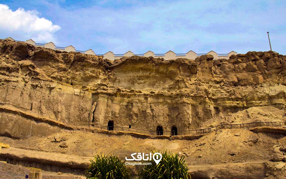نمای از ورودی غار خربس روی کوه و آسمان آبی بالای آن