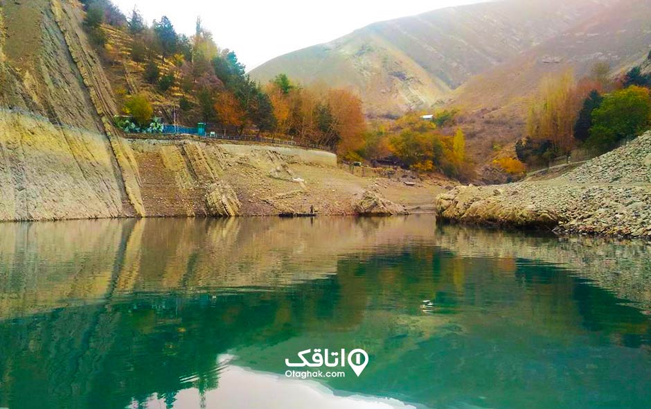 آب داخل سدی به نام امیر کبیر و درختان که در پاییز رنگی شده