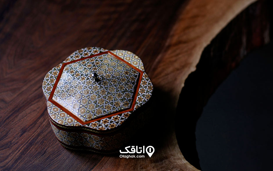 یک طرغ خاتم کاری شده روی یک میز چوبی