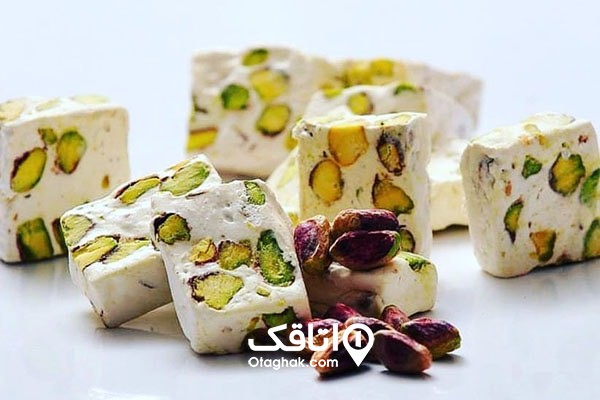 تعداد گز پسته و تعدادی مغز پسته خام در اطراف آن