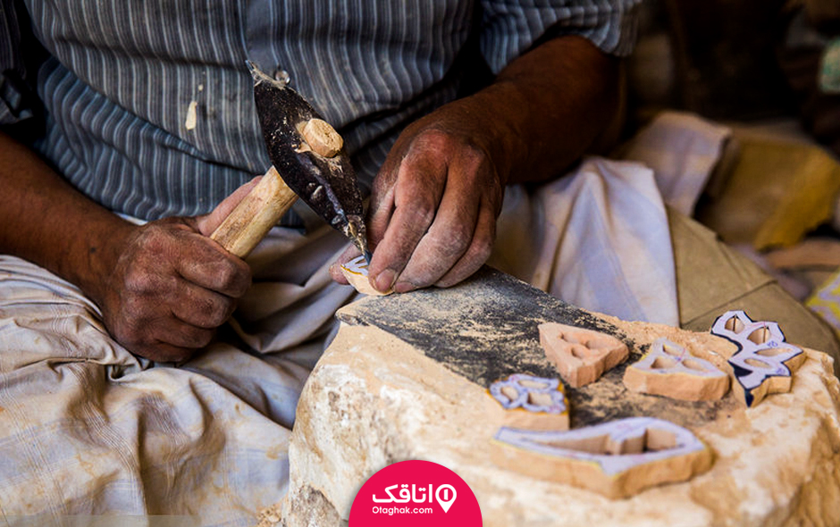 مردی در حال منبت کاری با ابزاری روی چوب