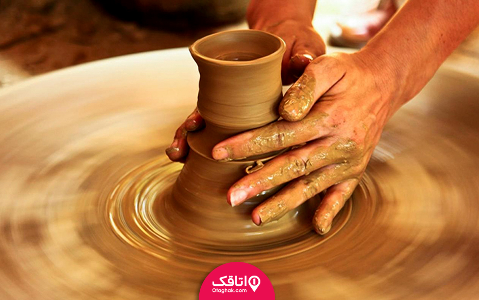 دستان آدمی در حال ساختن یک ظرف سفالی با گل رس روی چرخ