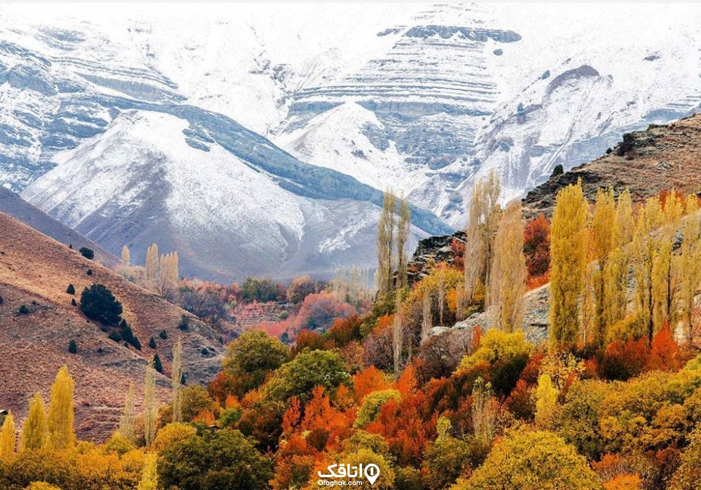 کوه های برفی و کوههای پر از درختان پاییزی با برگ های نارنجی و زرد مربوط به شهر فشم