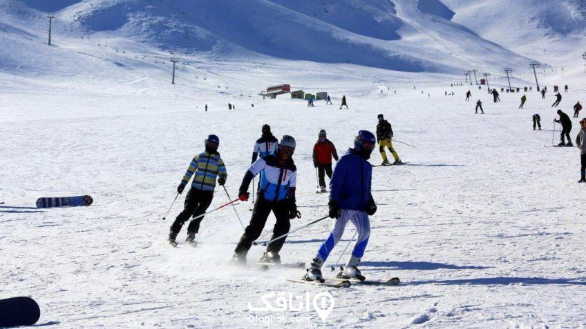 ده ها نفر درحال اسکی کردن با چوب و تجیزات ورزش اسکی و زمینی پوشیده از برف