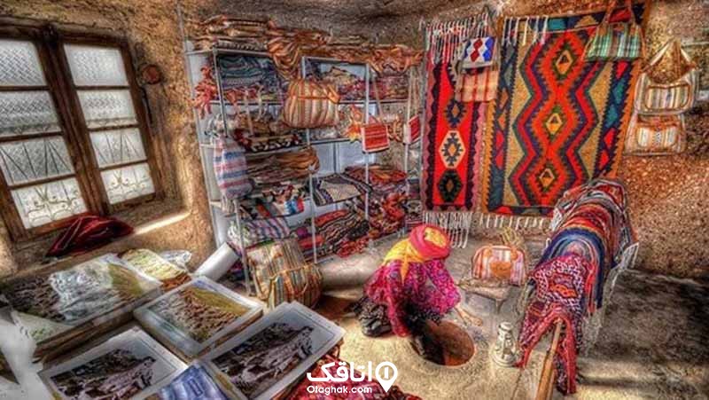 نقاشی از یک زن روستایی در یک حجره قالی بافی