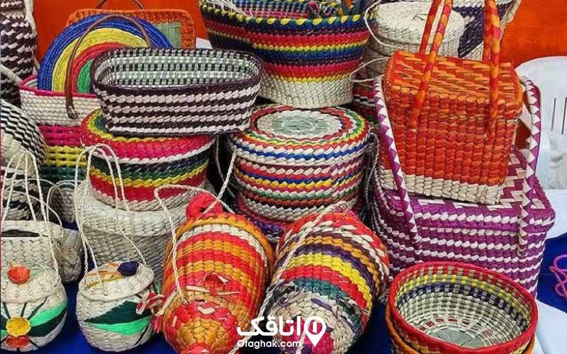 سبدهای حصیری و ظروف درب دار حصیری با رنگ و نقشهای مختلف در کنار هم