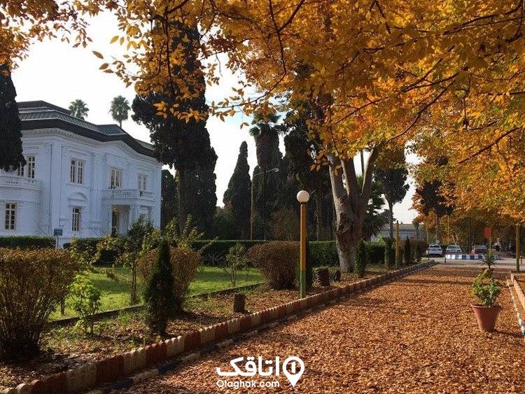 فضای پاییزی در بابلسر، یک ویلای دوبلکس سفید رنگ که درختان و جاده های دور آن پر از برگ زرد پاییزی است