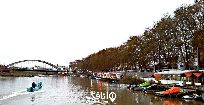 پارک و اسکله قایقرانی بابلسر بر روی بابلرود، یک قایق وسط رودخانه در حال حرکت است