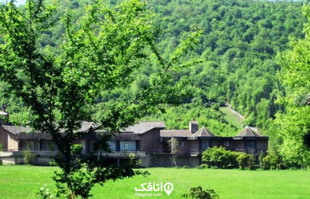 یک ساختمان یزرگ و قدیمی در دل طبیعت کوه هایی که از درخت پوشیده شده اند به نام کاخ ملکه مادر