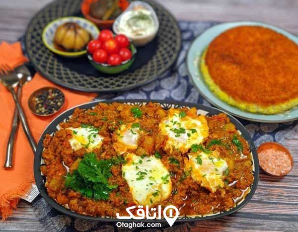 غذای محلی بیج بیج تزیی شده با تخم مرغ و سزی در کنار کاسه های کوچک ماست، سیر ترشی و گوچه گیلاسی و یک بشقاب برنج
