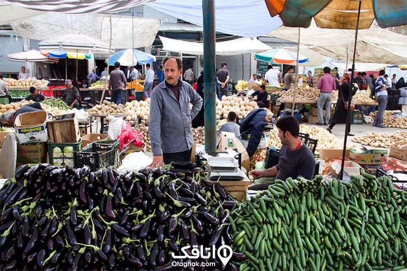 مقدار زیادی خیار و بادمجان و دو نفر که فروشنده انها در ان غرفه هستند، بارار روزی با غرفه های متعددو فروشندگان آنها