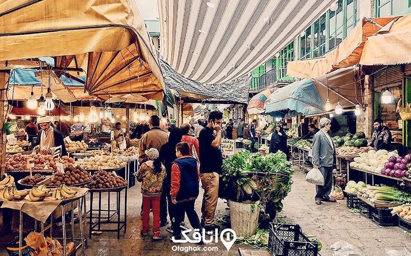 بازار روزی با فروشندگان مختلف مواد غذایی و مردم در حال خرید کردن