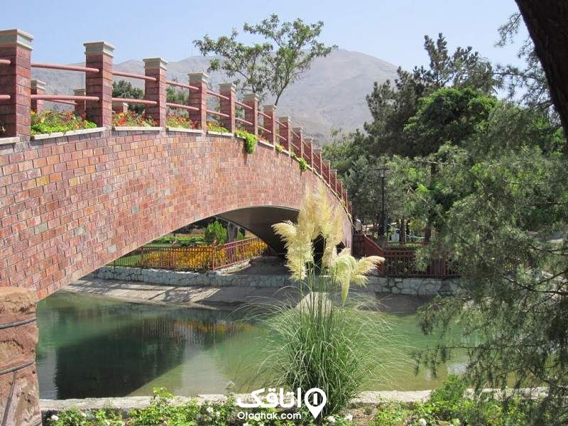 پلی آجری بر روی یک رودخانه و درختان سرسبز در اطراف آن