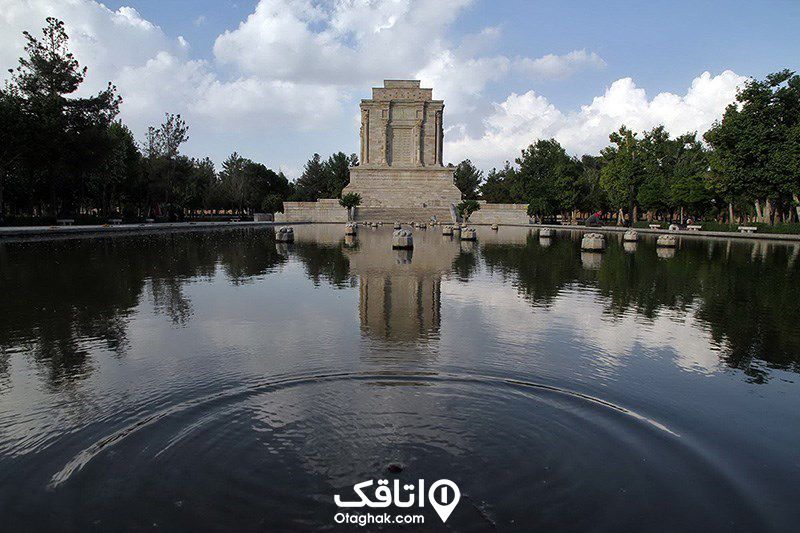 ساختمان نمادین مقبره قردوسی در میان محوطه سرسبز و رو به روی یک حوض بزرگ