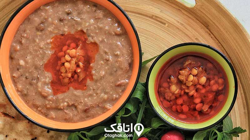 یک کاسه غذای شله مشهدی در یک سینی به همراه سبزی خوردن و نان