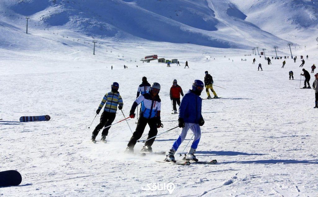 زمینی پوشیده شده از برف چندین نفر در حال انجام ورزش اسکی