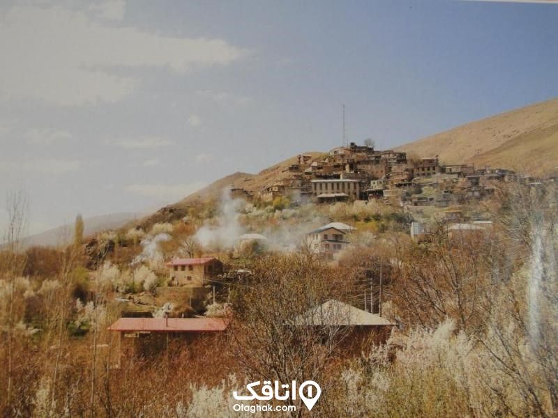 خانه های ساخته شده روی کوهستان، درختان بی برگ در زمستان روستای جَوَرد