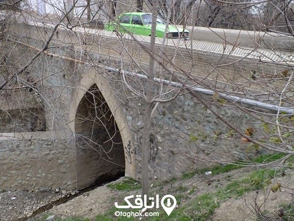 یک پل سنگی قدیمی که یک ماشین بز ر ال عبور از روی آن است