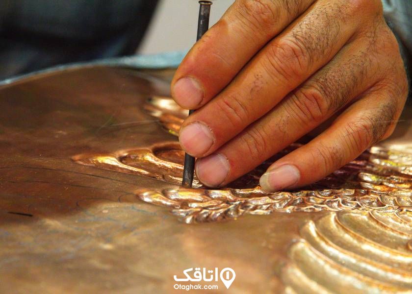 دست یک فرد در حال انجام هنر قلم زنی روی فلز