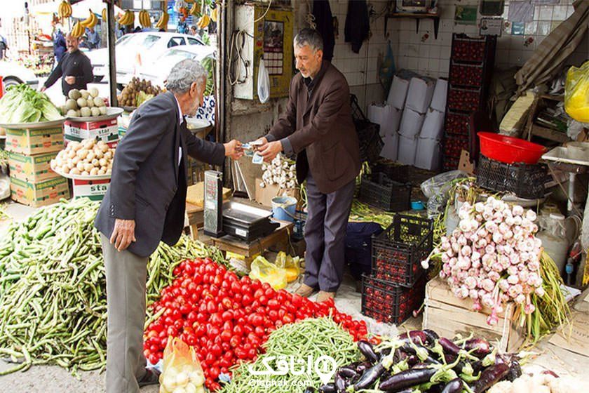 یک مغازه میوه فروشی، مردی در حال پرداخت پول به مرد فروشنده
