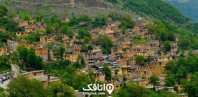 خانه های روستایی بین درختان سبز و بلند که بصورت پلکانی روی هم قرار گرفته اند.