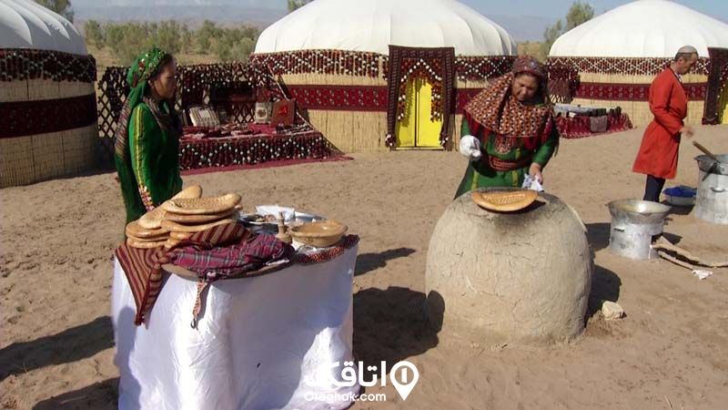 چند زن با لباس محلی در حال پخت نان در تنور و پشت آن ها چادر هایی کوچ نشینی مشخص است