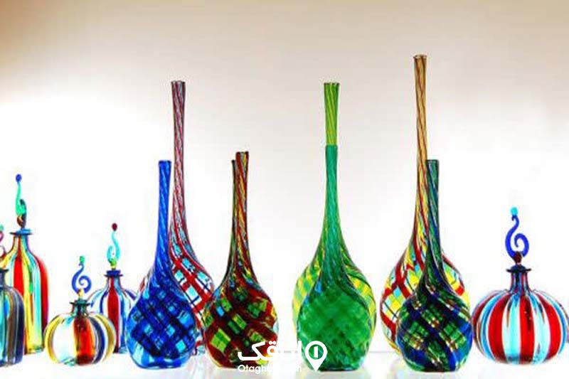 تعدادی شیشه با رنگ و فرم های مختلف که با هنر شیشه گری ساخته شده اند
