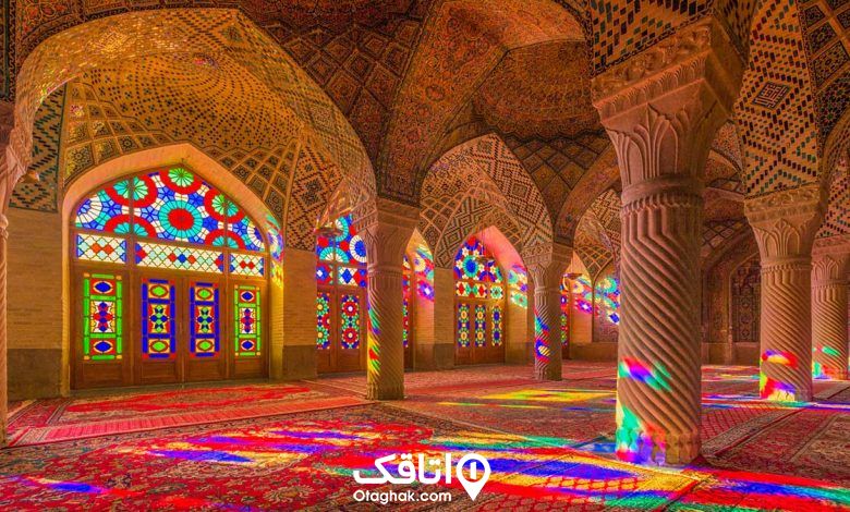 نمای داخلی مسجد نصیر الملک با پنجره های چوبی و شیشه هلی رنگی، سقف کاشی کاری سنتی و ستون های قطور