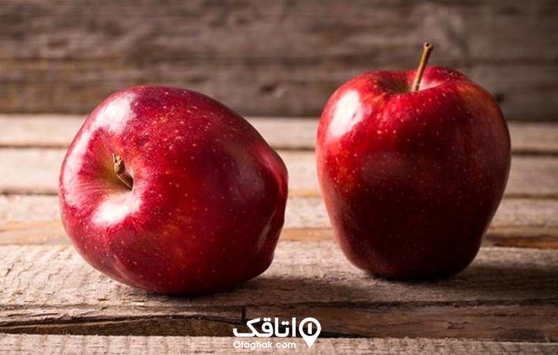دو عدد سیب سرخ بر روی یک میز