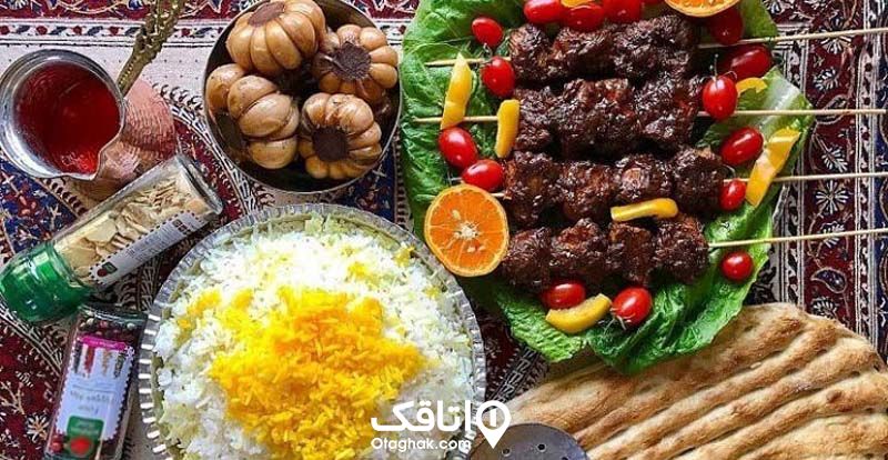 یک ظرف برنج و یک دیس کباب محلی به همراه دورچین و یک ظرف سیر ترشی