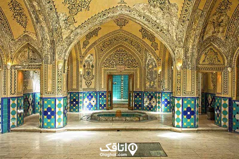 حمام تاریخی کاشان با شقف هایی طاقی و ستون هایی تزیین شده، دیواره هایی تا نیمه با کاشی کاری آبی رنگ و نیمه دیگر گچ کاری و نقاشی شده