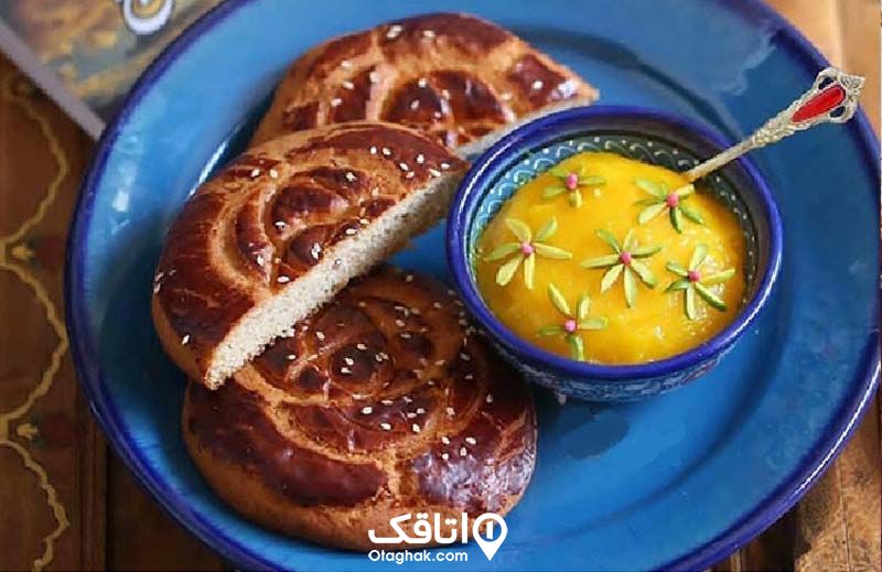 یک نوع نان محلی و یک کاسه کوچک شله زرد تزیین شده با پسته داخل بشقابی آبی رنگ
