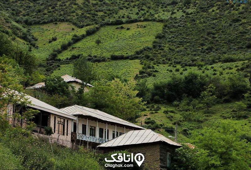 چمد خانه ویلایی با سقف شیروانی و ایوان در دل طبیعت کوه هایی سبز رنگ