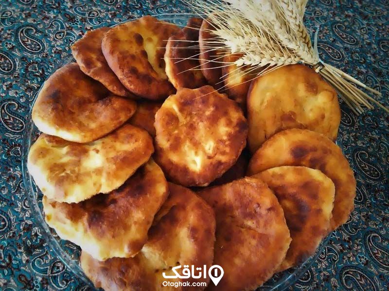 یک ظرف شیرینی مخصوص روستای ماسوله که در کنار آن چند خوشه گندم قرار گرفته
