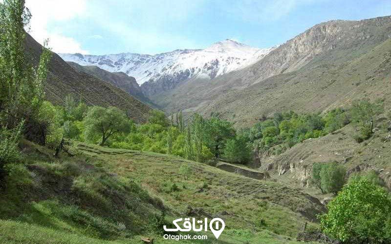 درع ای سرسیز در میان کوهستان و قله ای پوشیده از برف