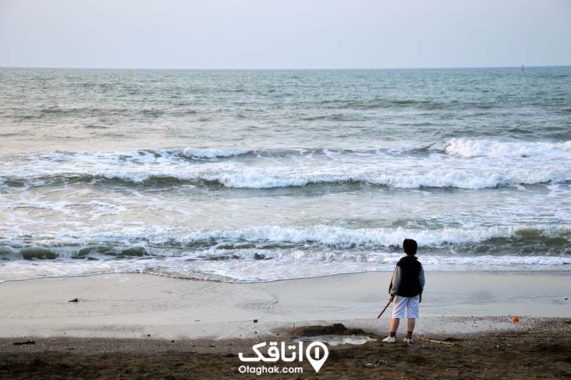 کودکی ایستاده در ساحل دریای خزر