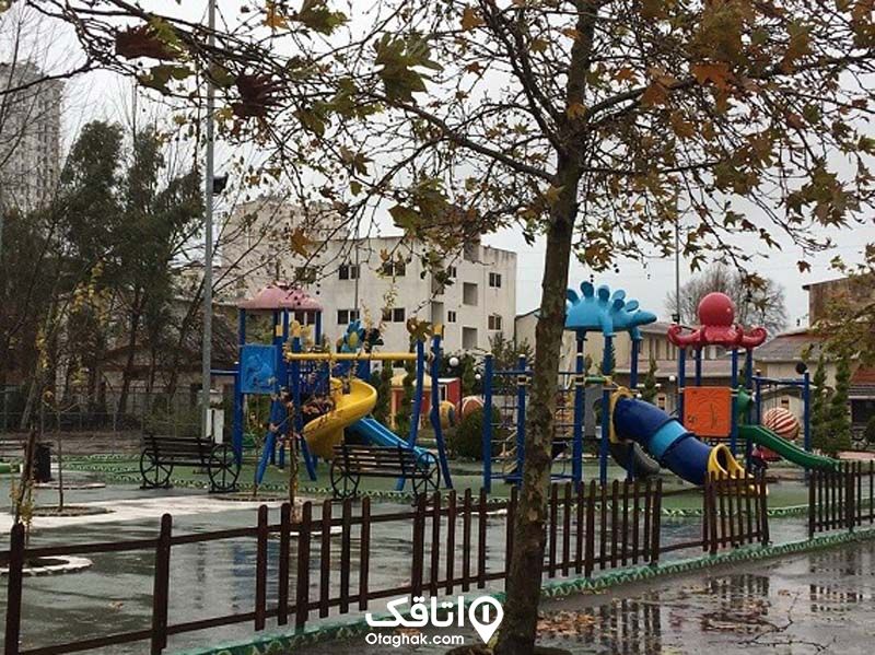 پارک محلی با وسایل بازی رنگی برای کودکان، سرسره های آبی، زرد، قرمز ، تاب های رنگی