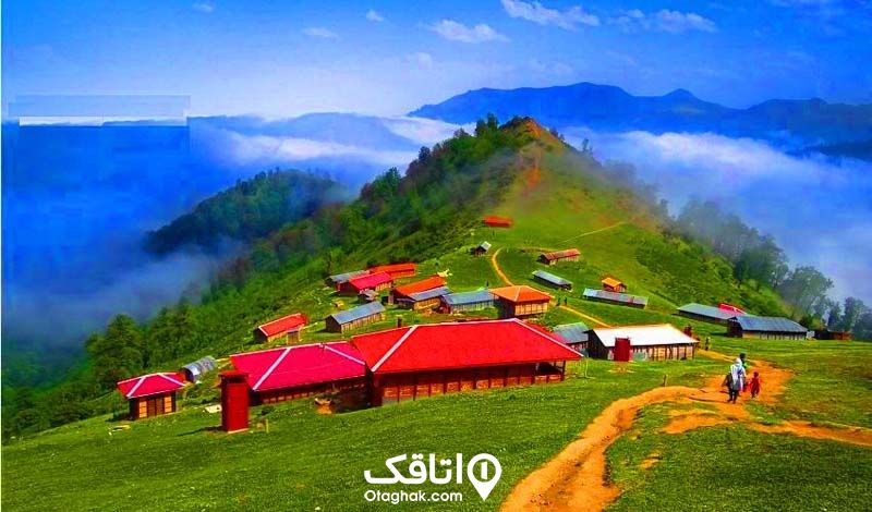 خانه های ویلایی روستایی روی کوهستان جنگلی با جنگل ابر اطراف کوه