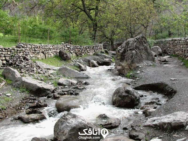 رودخانه کرگان رود تالش در حال عبور بین دو باغ و سنگ های بزرگی که سر راهش قرار دارند.