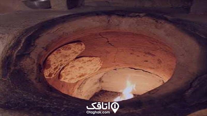 تنور سفالی و دو نان در حال پختن درون آن