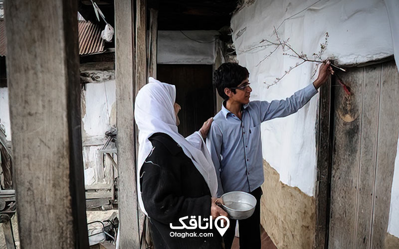 مادر و پسر کنار در ورودی چوبی یک خانه