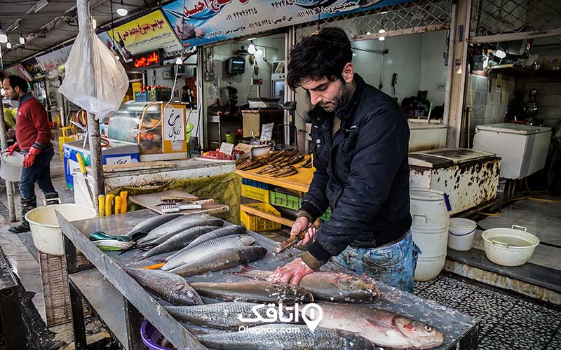 مردی در حال پاک کردن ماهی در بازار ماهی فروشان