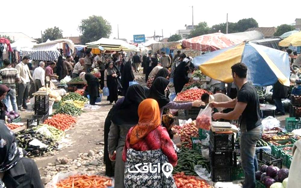 بازار محلی مواد خوراکی تازه و مردمی که در حال خرید هستند.