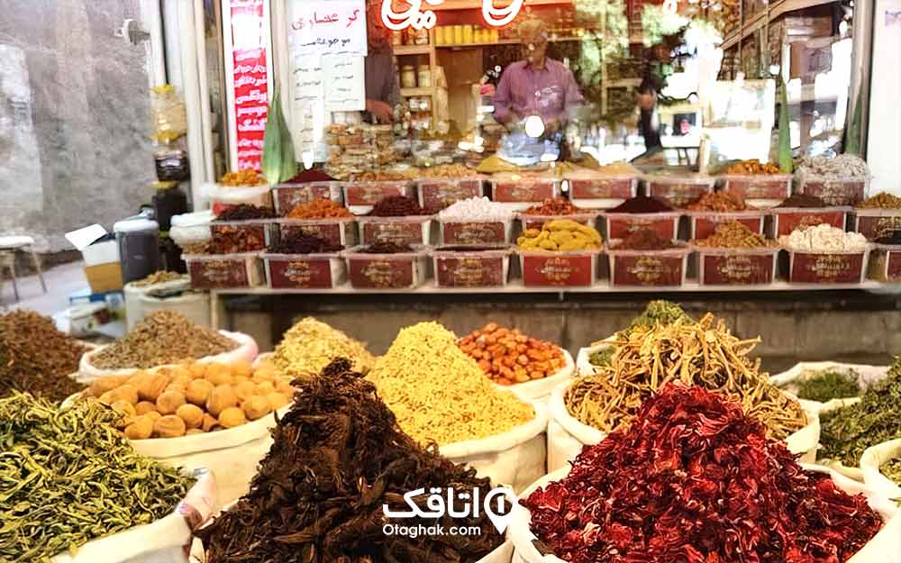 یک مغازه عطاری و انواع گیاهان و خوراکی های خشک جلوی مغازه