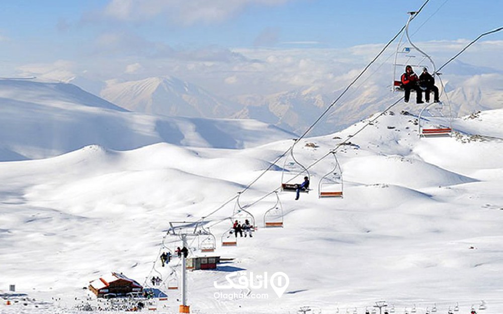 کوهستان پوشیده از برف و تل اسکی که تعدادی آدم سوار آن هستند