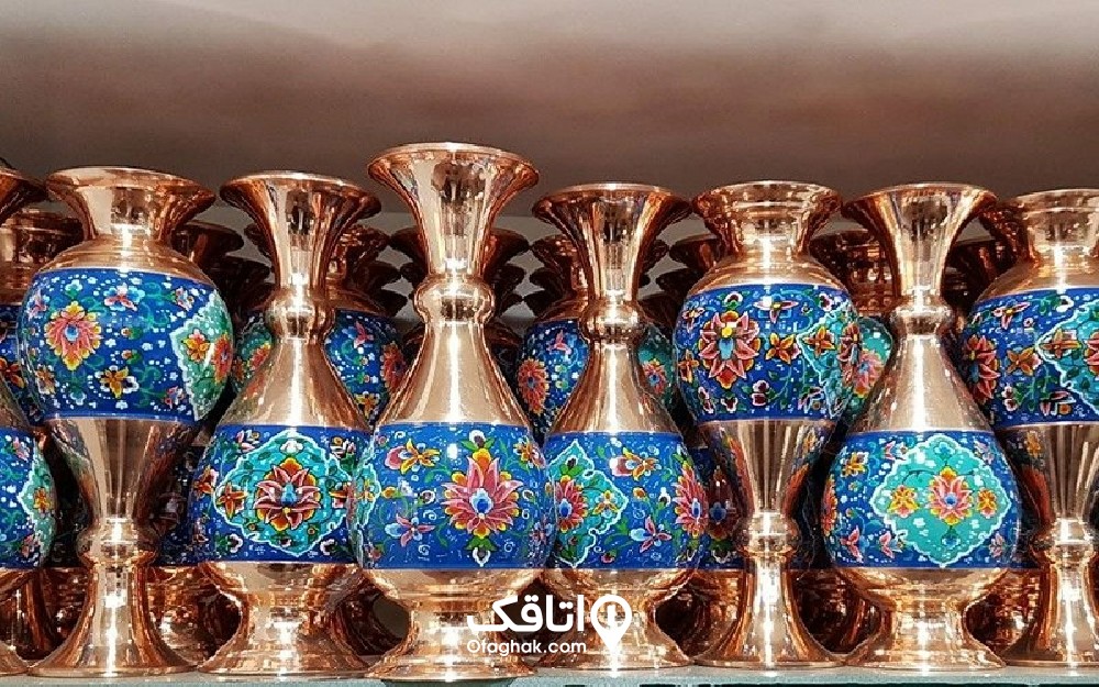 چندین گلدان مسی و میناکاری آبی روی آنها